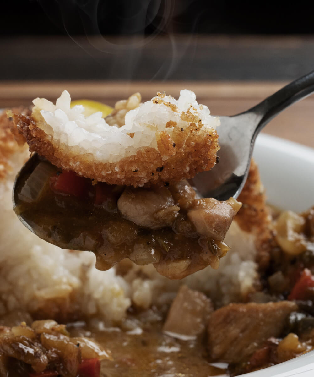 スプーンですくったライスコロッケカレーの写真